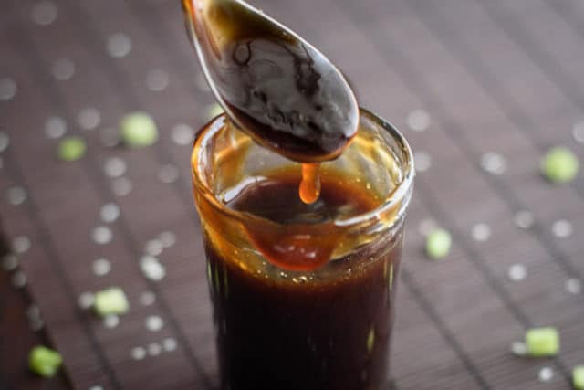 horizontal photo of teriyaki sauce dripping off a spoon